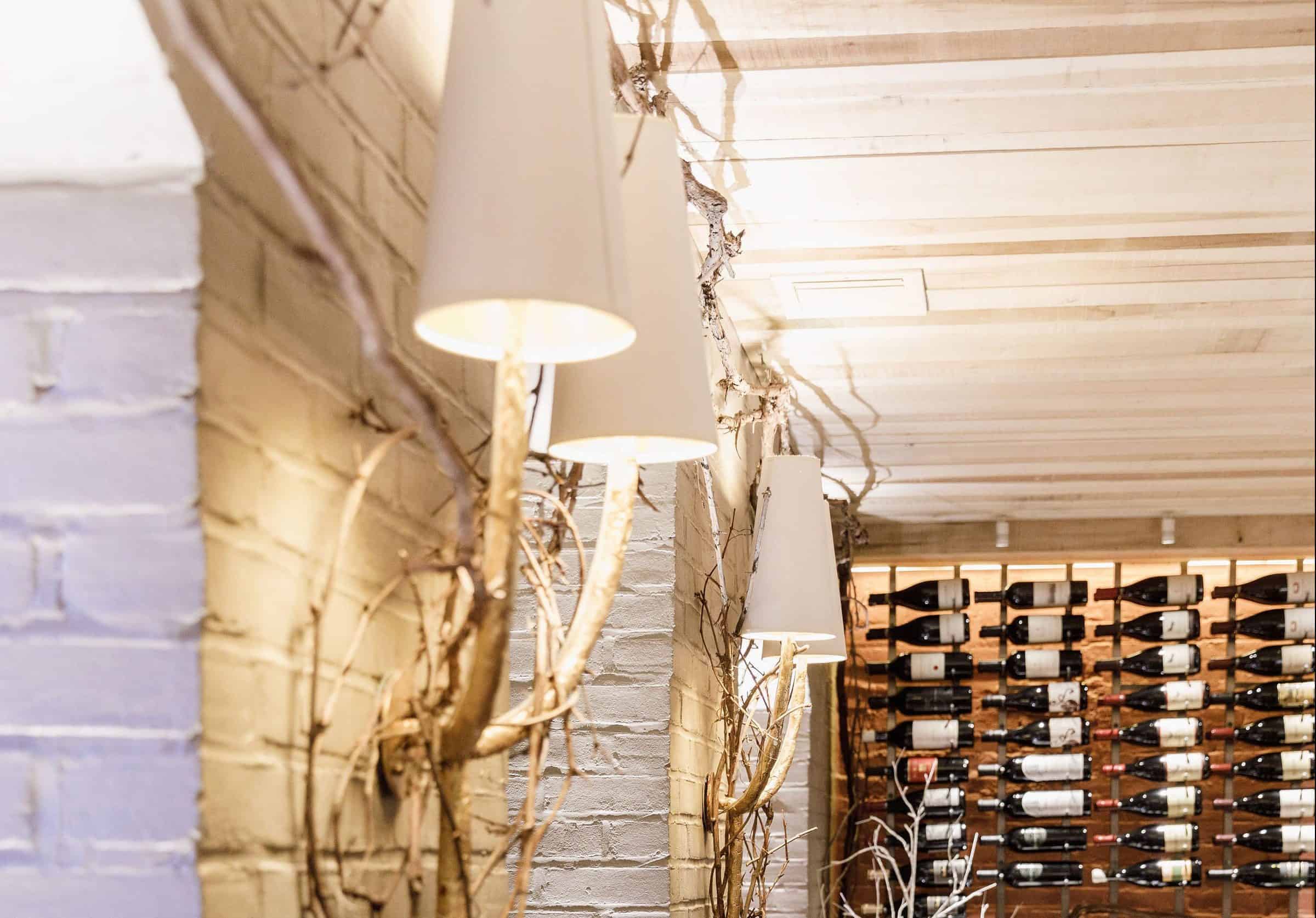 Wall sconces with rustic vines and wine racks in the Robert Parker Wine Cellar at Magdalena Restaurant.