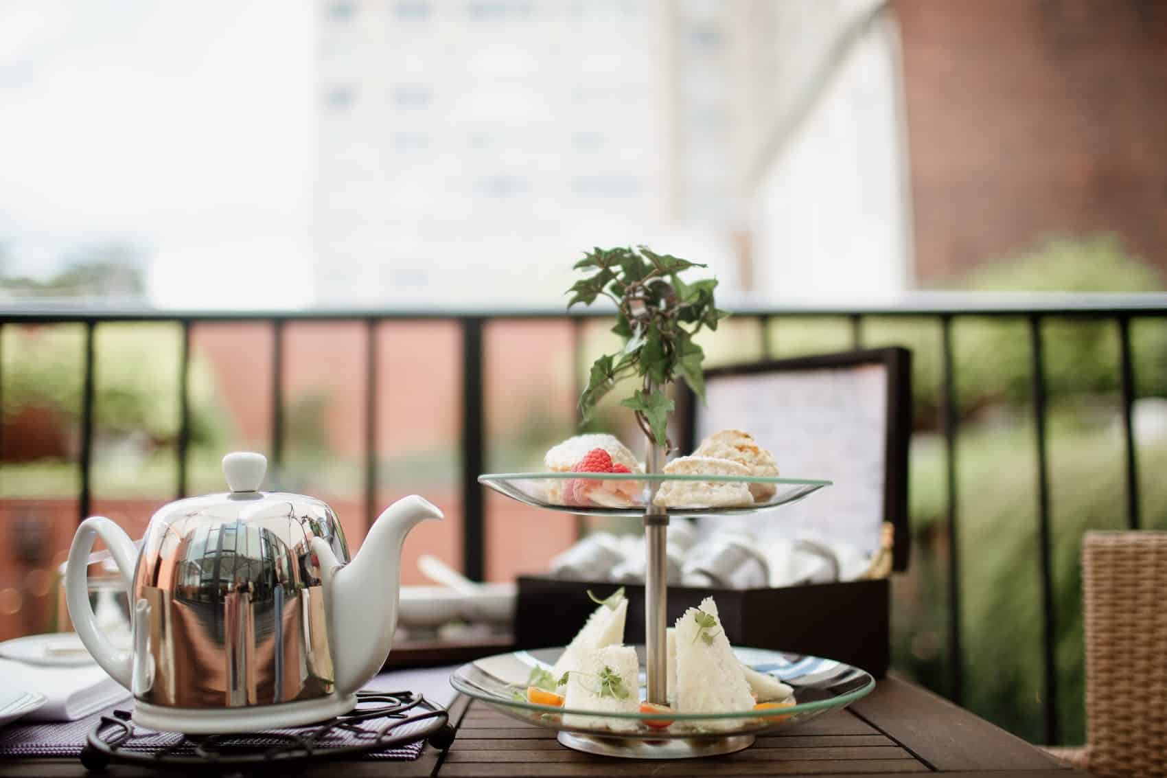 Teapot next to sandwiches on the terrace at The Ivy Hotel.
